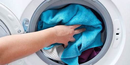 Bỏ khăn vào máy giặt, và để máy giặt ở chế độ nước nóng